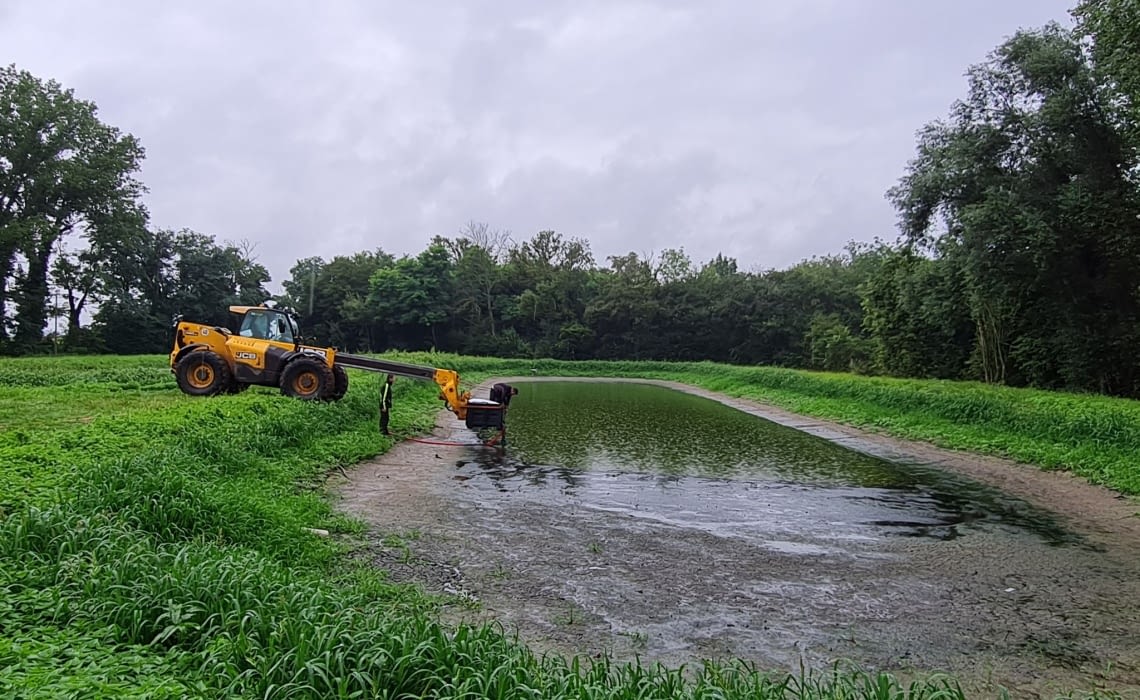 Engin de chantier JCB avec passerelle téléscopique et deux hommes avec bassin d'eau