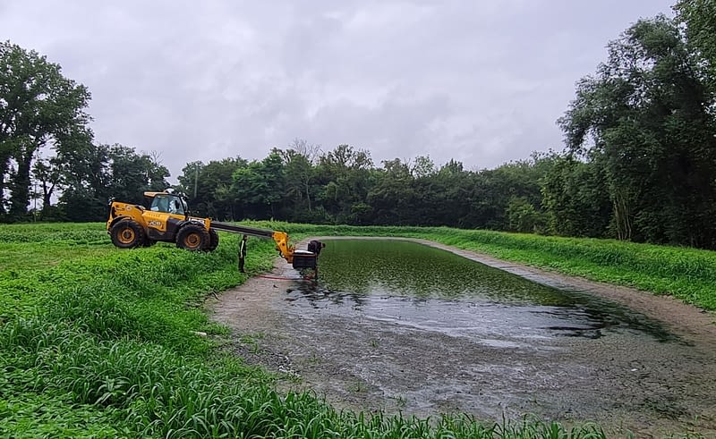 Engin de chantier JCB avec passerelle téléscopique et deux hommes avec bassin d'eau