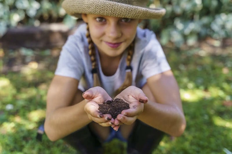 Enfant avec tas de terre dans les mains