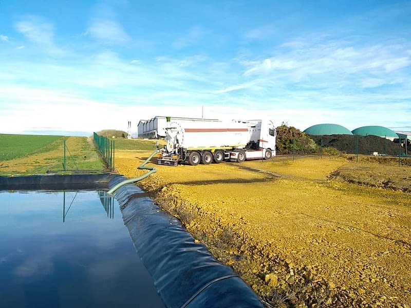 Camion récupérant de l'eau dans une bassine avec bâche noir